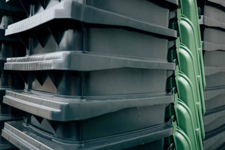 Nahaufnahme von gestapelten Papiertonnen (mit grünem Deckel) der StadtWerke Rösrath