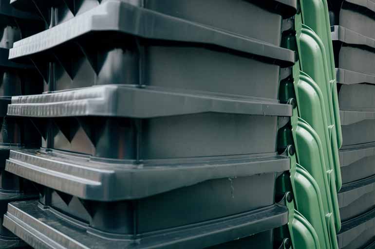 Nahaufnahme von gestapelten Papiertonnen (mit grünem Deckel) der StadtWerke Rösrath