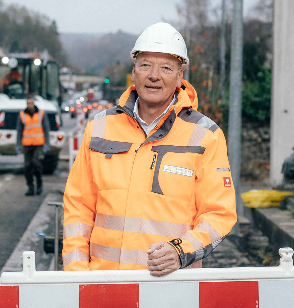 Eine Führungskraft der StadtWerke Rösrath in Arbeitskleidung und Helm auf einer Baustelle.