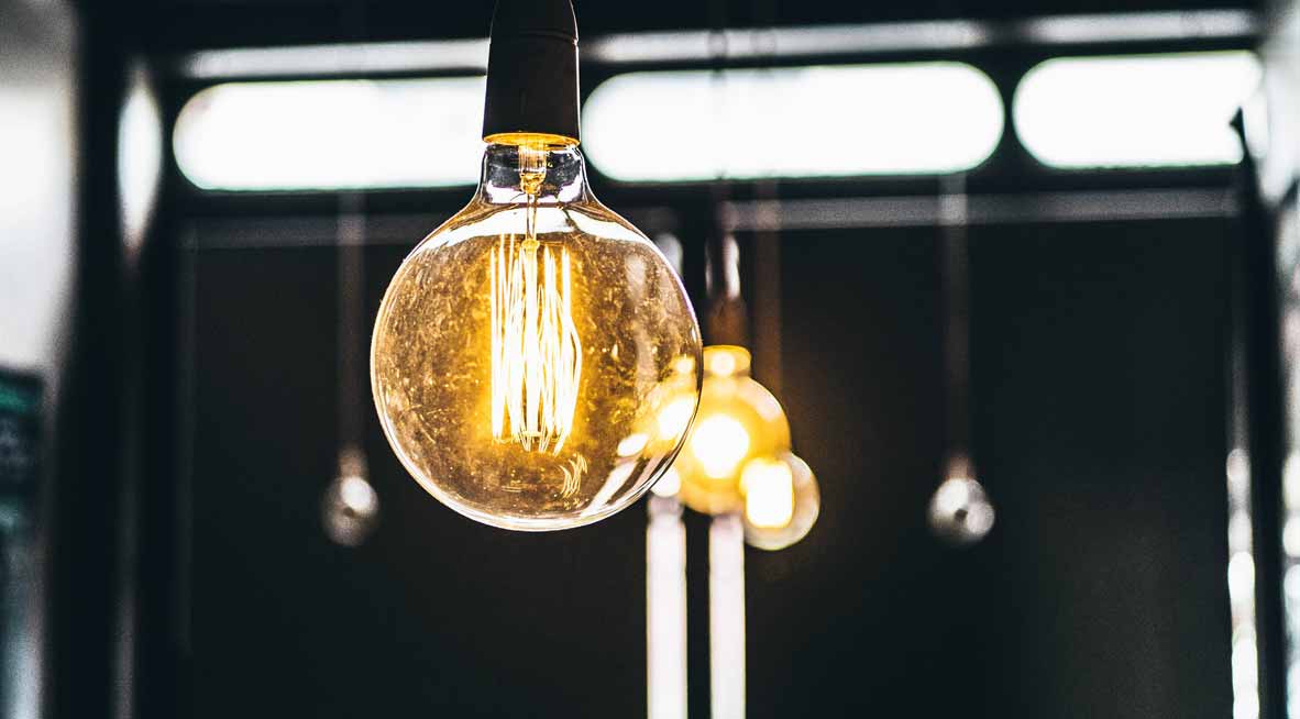 Brennende Lampen, die nur aus einer Fassung mit großen Glühbirnen bestehen.