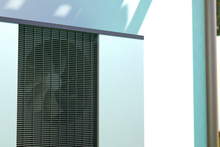 Eine Wärmepumpe an einer Hauswand im Garten