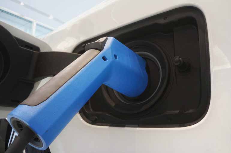 Nahaufnahme eines Ladekabels, welches in einem Elektro-Auto eingesteckt ist.