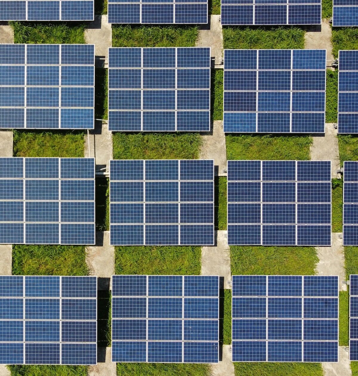 Aufnahme von oben auf große Solaranlagen auf einem Feld
