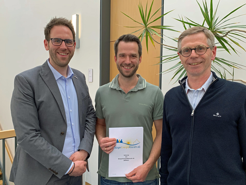 Drei Männer schauen fröhlich in die Kamera. Einer von ihnen ist Christoph Schmidt, Vorstand der StadtWerke Rösrath AöR